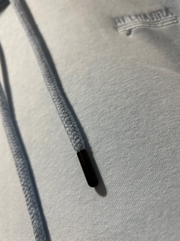 Gros plan sur les cordons avec embouts métalliques du hoodie Belharra Bleu Glacier