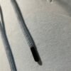 Gros plan sur les cordons avec embouts métalliques du hoodie Belharra Bleu Glacier